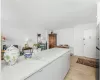 Kitchen featuring light wood-type flooring, white cabinetry, and light stone countertops