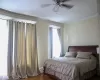 Bedroom with hardwood / wood-style flooring, ceiling fan, and multiple windows