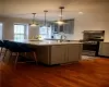 Kitchen with gas stove, sink, gray cabinetry, tasteful backsplash, and dark hardwood / wood-style flooring