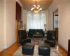 Living room with parquet flooring, an inviting chandelier, and crown molding