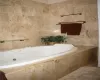 Bathroom featuring tile walls and a relaxing tiled tub