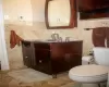 Bathroom featuring backsplash, vanity, toilet, and tile patterned flooring