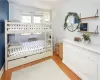 Bedroom featuring light hardwood / wood-style floors and an AC wall unit