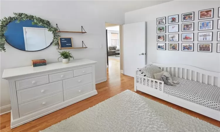 Bedroom featuring light hardwood / wood-style floors and a crib