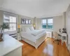 Bedroom featuring light hardwood / wood-style flooring, multiple windows, and radiator heating unit