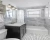 Full bathroom with shower / bath combo with shower curtain, tile patterned flooring, tile walls, toilet, and vanity