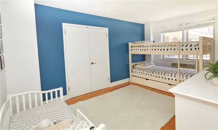 Bedroom with light hardwood / wood-style flooring and a closet