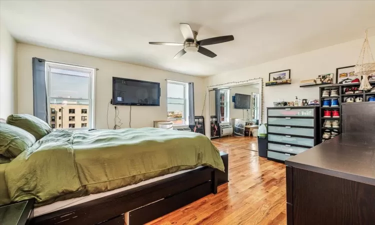 Bedroom featuring ceiling fan, light hardwood / wood-style floors, and a closet