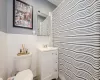 Bathroom with vanity, tile walls, and toilet