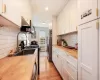 Kitchen featuring white cabinets, wood counters, light hardwood / wood-style floors, and stainless steel appliances