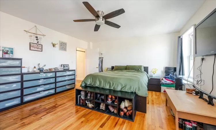 Bedroom with a closet, hardwood / wood-style flooring, and ceiling fan