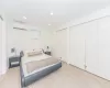 Bedroom with light wood-type flooring, two closets, and a wall unit AC