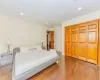 Bedroom with hardwood / wood-style floors, ornamental molding, and a closet