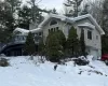 View of snow covered exterior with a garage and a wooden deck