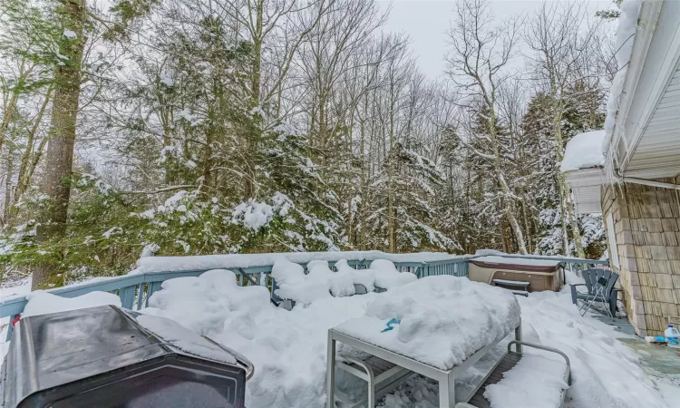 Snowy yard featuring a hot tub