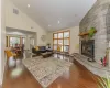 Living room featuring plenty of natural light, a fireplace, dark wood-type flooring, and high vaulted ceiling