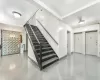 Stairway with tile walls and a notable chandelier