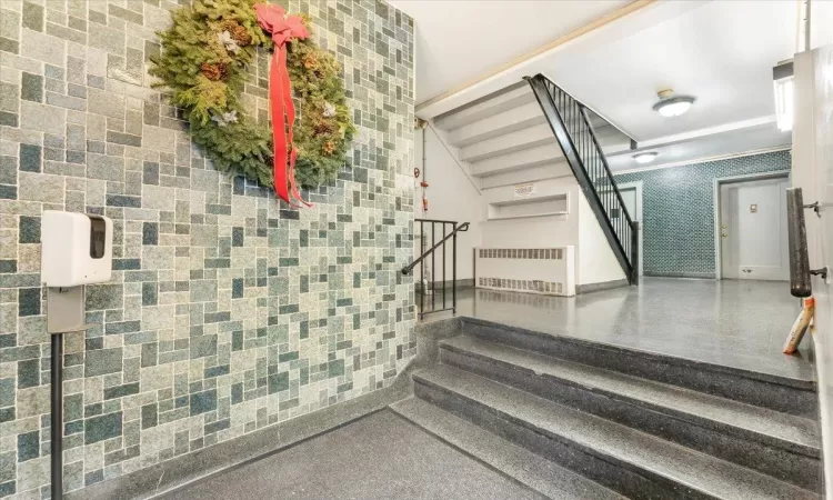 Staircase with tile walls and radiator