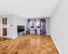 Unfurnished living room featuring radiator and light parquet floors