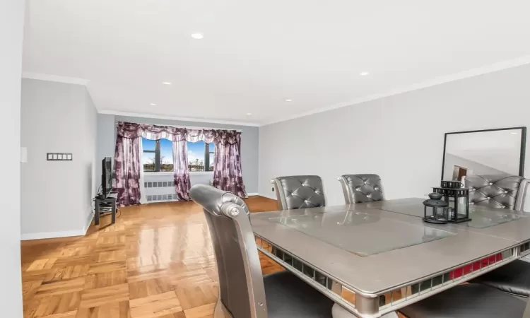 Dining space featuring ornamental molding and light parquet flooring