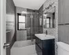 Full bathroom featuring bath / shower combo with glass door, vanity, tile walls, tile patterned flooring, and toilet