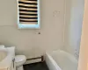 Bathroom featuring vanity, a baseboard heating unit, tile patterned floors, a washtub, and tile walls