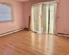 Empty room featuring light wood-type flooring and a baseboard radiator