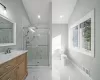 Bathroom with a shower with door, vanity, vaulted ceiling, and toilet