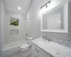 Full bathroom with vanity, toilet, tiled shower / bath, and lofted ceiling