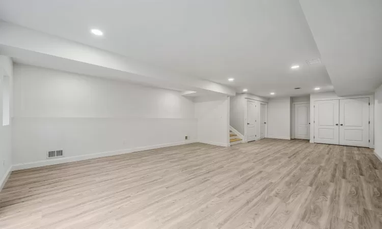 Basement with light hardwood / wood-style floors