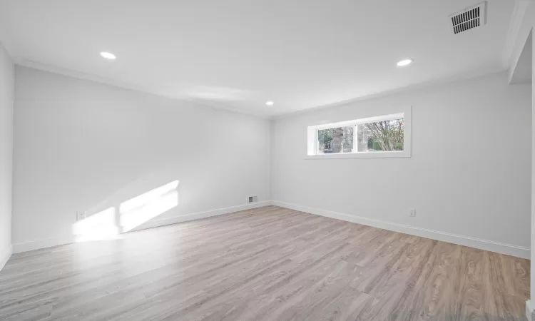 Unfurnished room featuring light wood-type flooring and crown molding