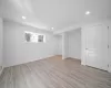 Basement with light hardwood / wood-style floors and crown molding