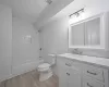 Full bathroom featuring vanity, tiled shower / bath combo, hardwood / wood-style flooring, and toilet