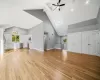 Unfurnished living room with beam ceiling, a skylight, ceiling fan, high vaulted ceiling, and light wood-type flooring