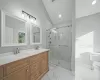 Bathroom with vanity, toilet, lofted ceiling, and a shower with door