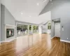 Unfurnished living room featuring light hardwood / wood-style floors, a tile fireplace, and high vaulted ceiling