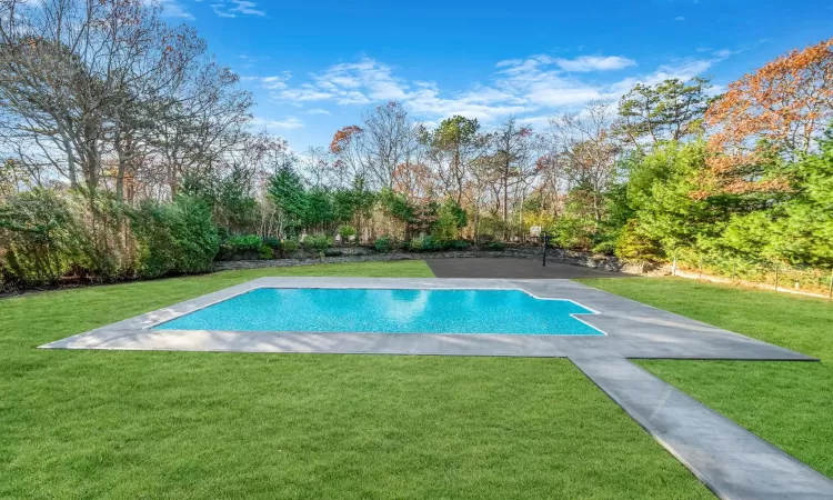 View of pool with a yard