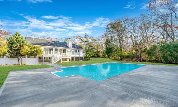 View of swimming pool with a lawn and a wooden deck