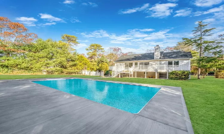 View of swimming pool with a lawn and a wooden deck