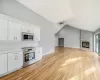 Kitchen featuring ceiling fan, tasteful backsplash, light hardwood / wood-style floors, white cabinets, and appliances with stainless steel finishes