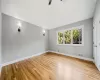 Empty room with ceiling fan, light hardwood / wood-style flooring, and vaulted ceiling