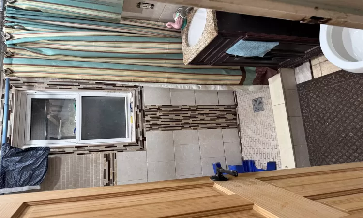 Bathroom featuring curtained shower, tile patterned flooring, vanity, and toilet