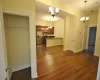 Kitchen with dark hardwood / wood-style flooring, stainless steel appliances, and an inviting chandelier