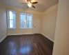 Unfurnished room featuring ceiling fan and dark wood-type flooring