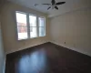 Empty room with dark hardwood / wood-style flooring and ceiling fan