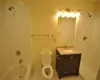 Full bathroom with vanity, tile patterned flooring, tiled shower / bath, and toilet