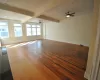 Spare room featuring beamed ceiling, dark hardwood / wood-style flooring, and ceiling fan