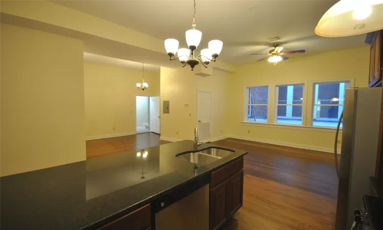 Kitchen with dishwasher, hanging light fixtures, dark hardwood / wood-style floors, and sink