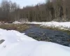 View of snowy yard and stream