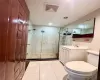 Bathroom featuring toilet, vanity, tile patterned floors, and a shower with shower door